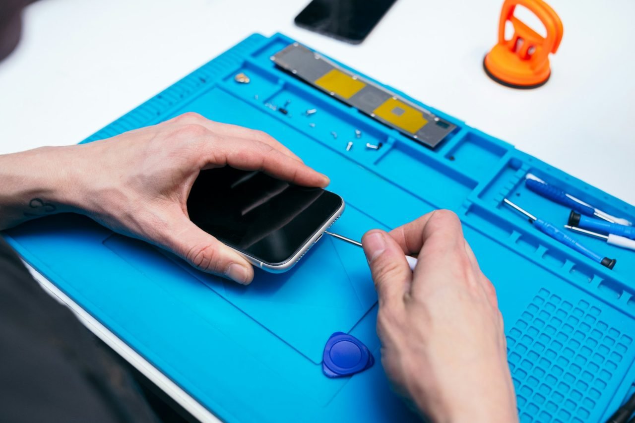Technician disassembling smartphone for repair